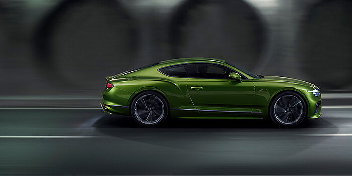  Bentley Hatfield Bentley Continental GT coupe in Tourmaline Green paint driving in profile on a dark road