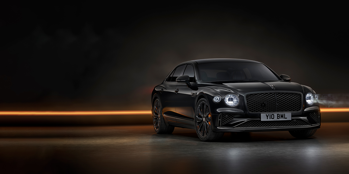 Bentley Hatfield Bentley Flying Spur Black Edition sedan in Black Crystal paint against a dark grey and copper coloured background