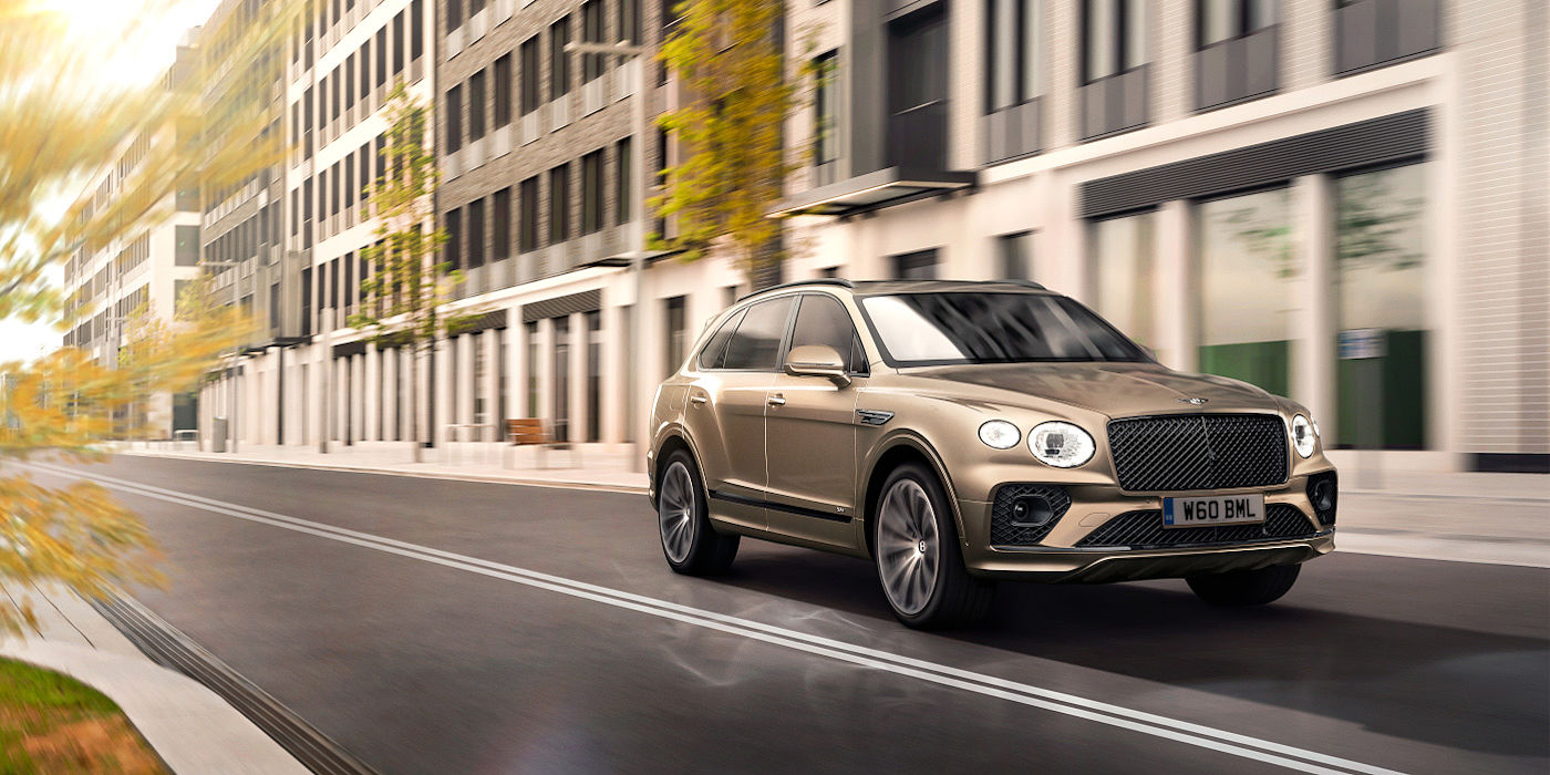 new-bentley-bentayga-hybrid-in-patina-paint-front-three-quarters-driving-through-london