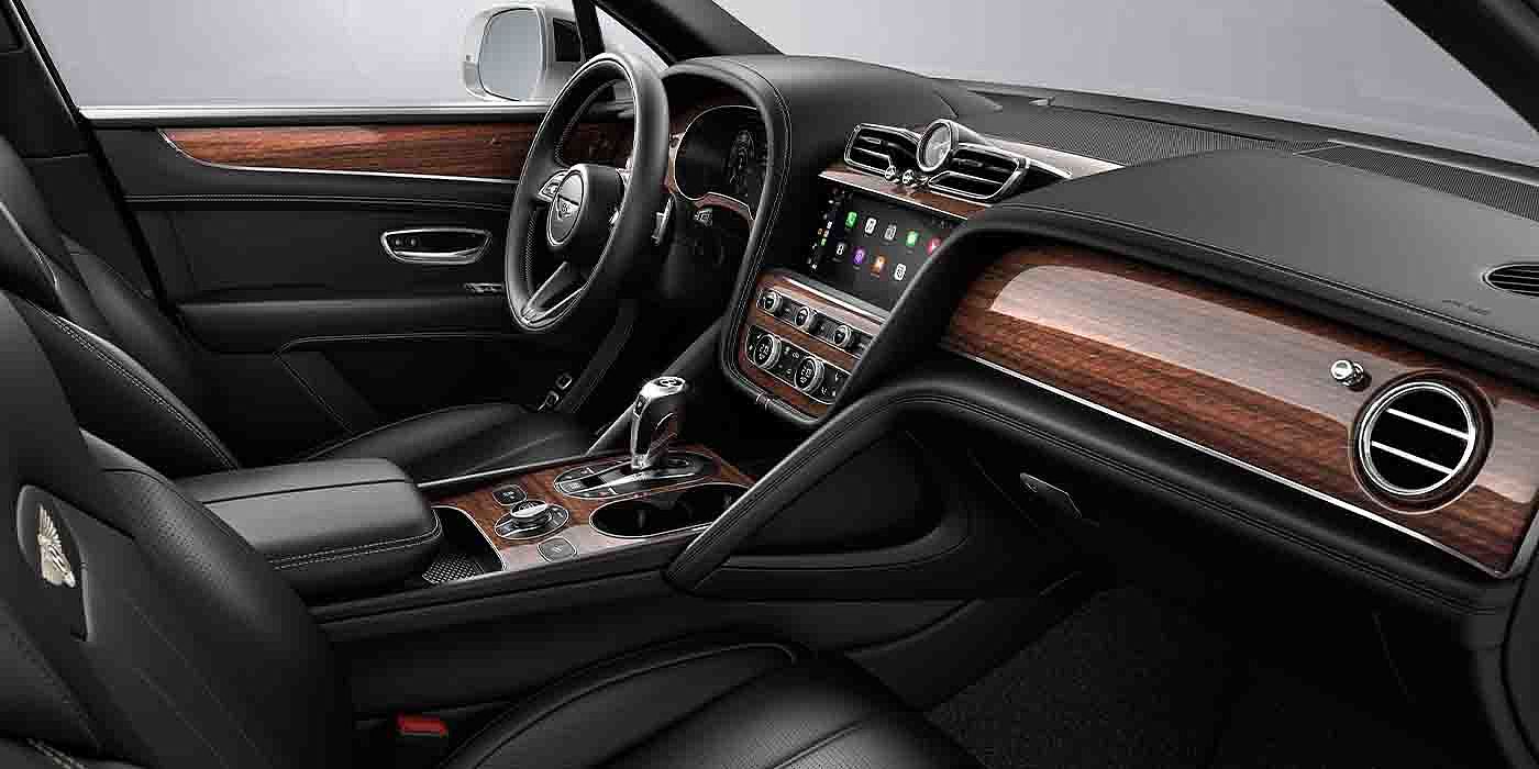 Bentley Hatfield Bentley Bentayga EWB interior with a Crown Cut Walnut veneer, view from the passenger seat over looking the driver's seat.