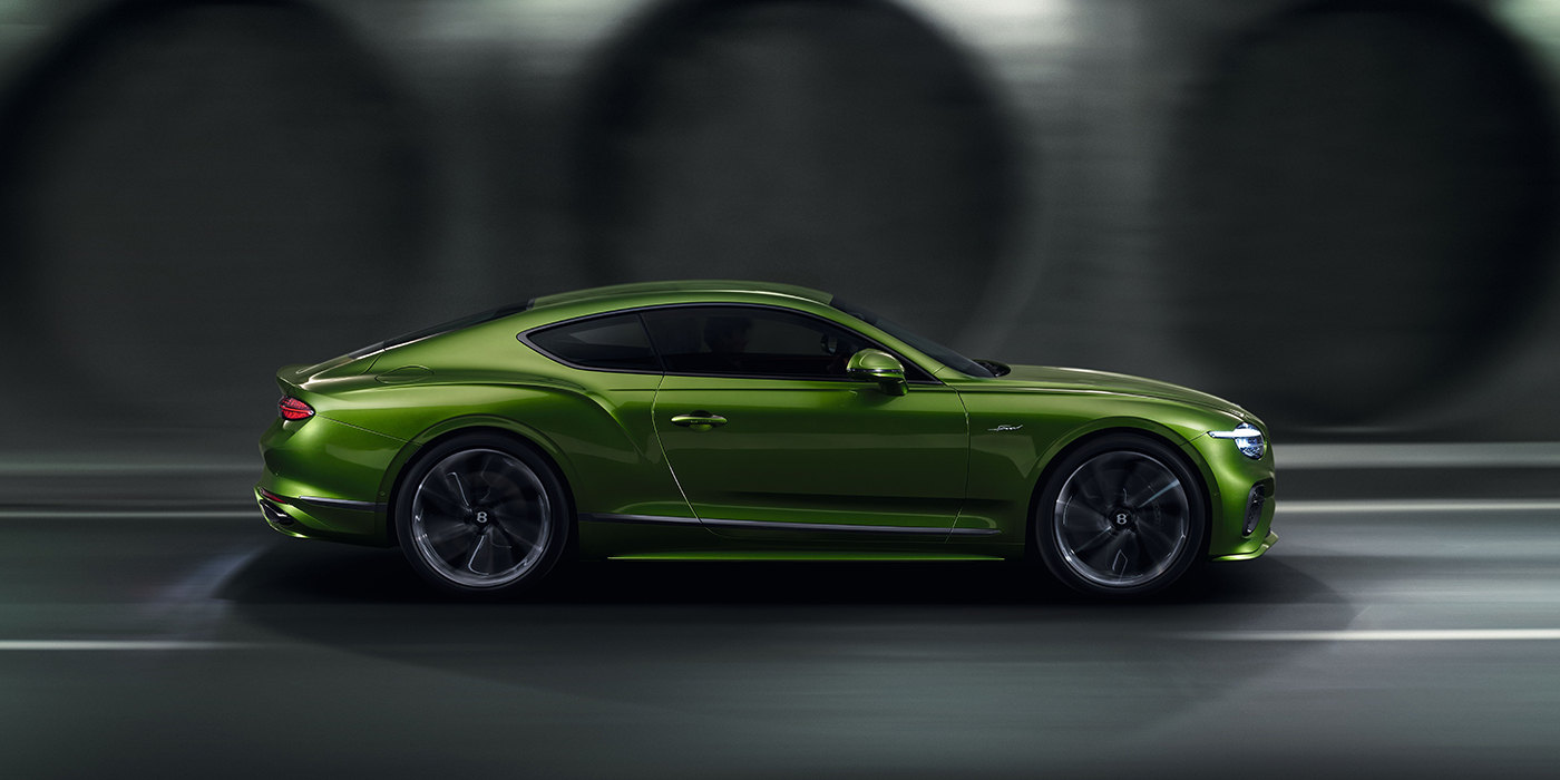 Bentley Hatfield Bentley Continental GT coupe in Tourmaline Green paint driving in profile on a dark road