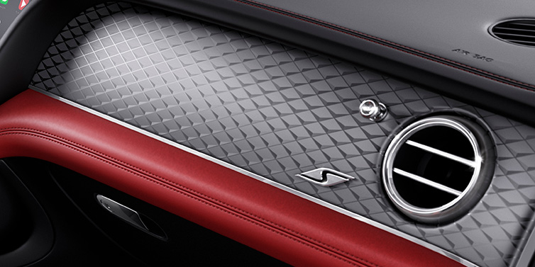 Bentley Hatfield Bentley Bentayga S SUV front interior dash with Dark Tint Diamond Brushed Aluminium veneer and S badge surrounded by Hotspur red and Beluga black hide