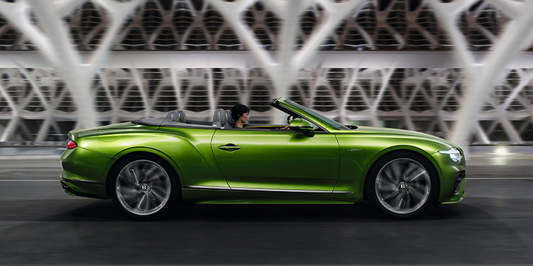 Bentley Hatfield Bentley Continental GTC Speed convertible side profile in Tourmaline Green paint driving dynamically on a bridge at night