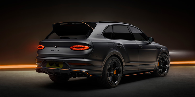 Bentley Hatfield Bentley Bentayga S Black Edition SUV rear three quarter in Anthracite Satin paint against a dark red and yellow background