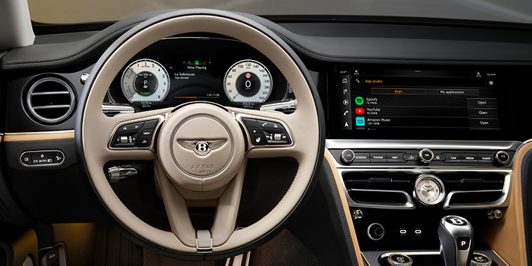 Bentley Hatfield Bentley Flying Spur Mulliner sedan front interior detail of steering wheel and driver screens surrounded by Linen and Beluga black hides