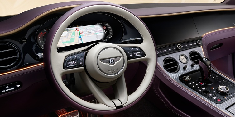 Bentley Hatfield Bentley Continental GT Mulliner coupe front interior showing steering wheel and drivers screens surrounded by Linen and Damson hides and Grand Black veneer